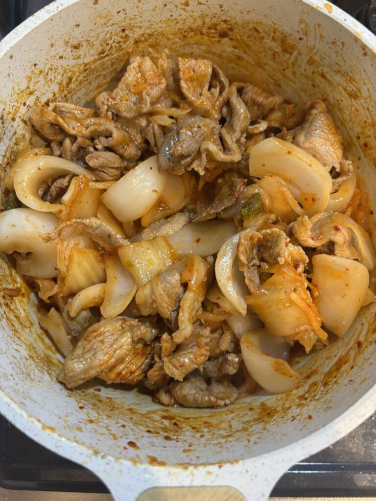 鍋で、豚肉、玉ねぎ、キムチを投入し炒めた後の様子