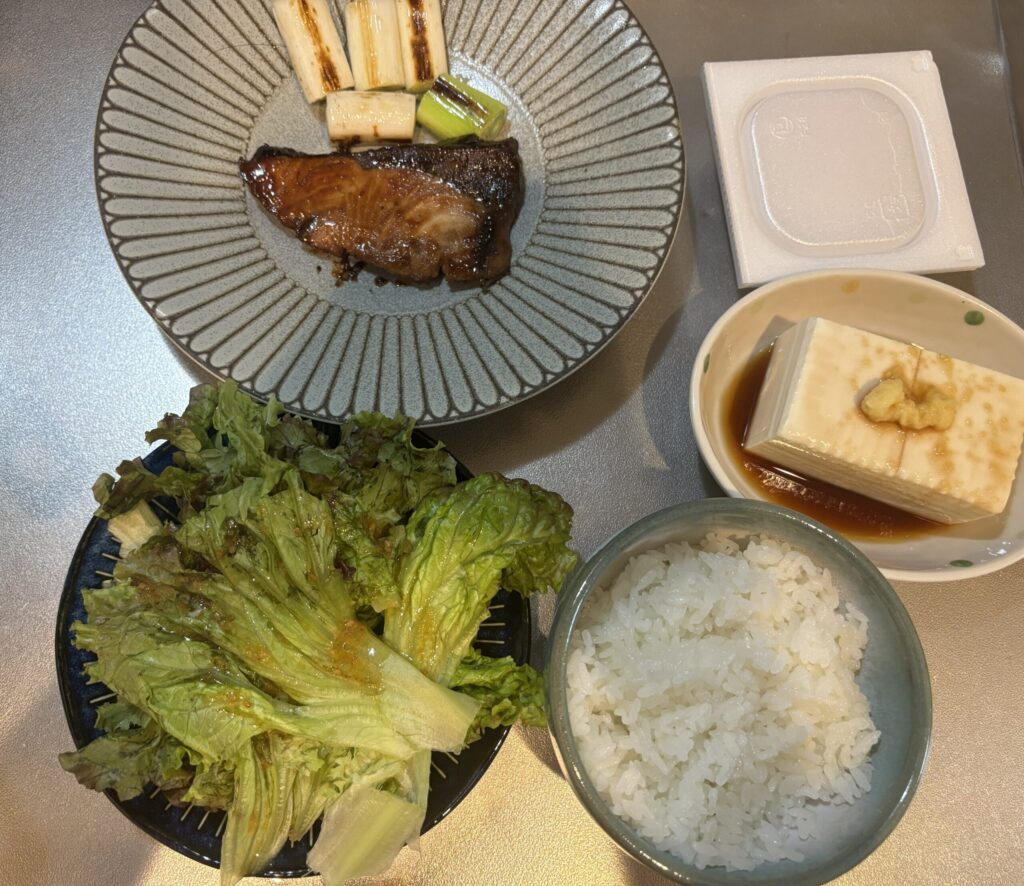 実際の献立。ぶりの照り焼き、焼いたネギ、サラダ、冷奴、納豆、ご飯。